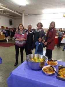 Volunteers smiling at a potluck